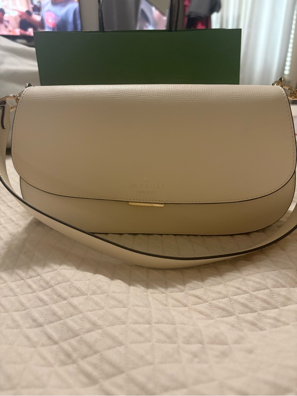 kate spade cream leather curved shoulder bag with gold hardware.